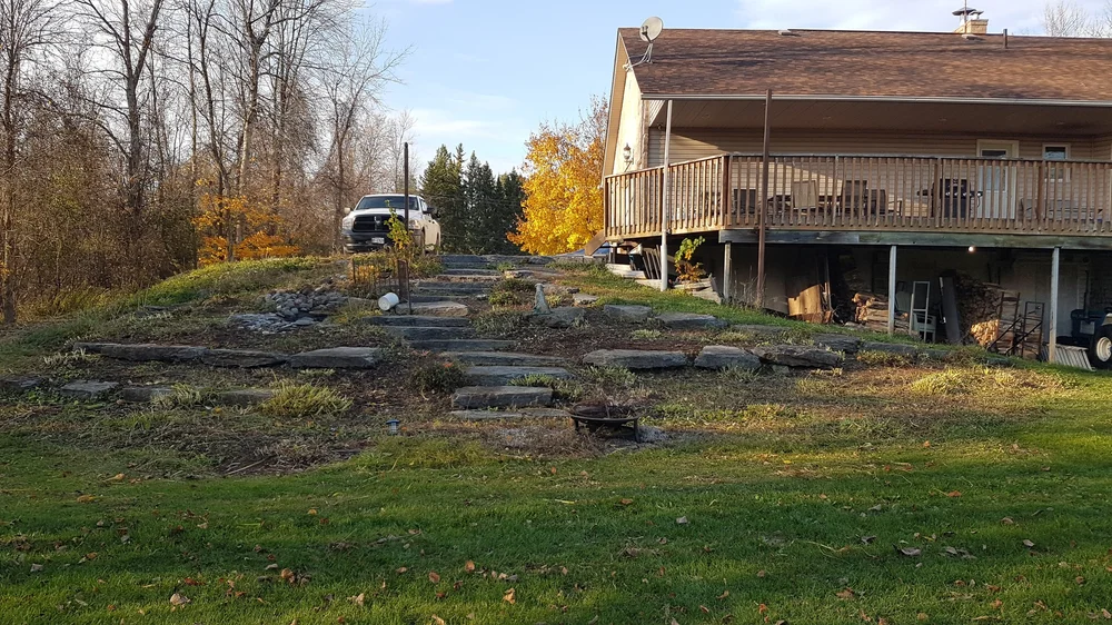 Rural house with wooden deck and stone steps