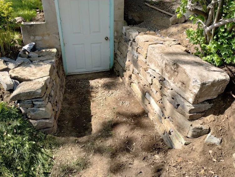 Stone retaining walls framing basement entrance door