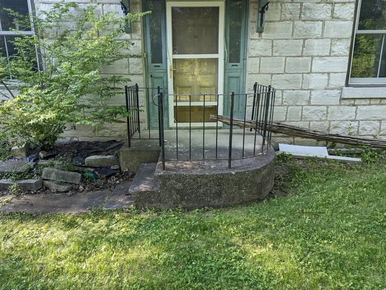 Stone house entrance with small concrete porch