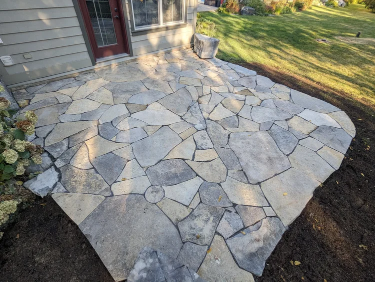Irregular flagstone patio in front of house entrance