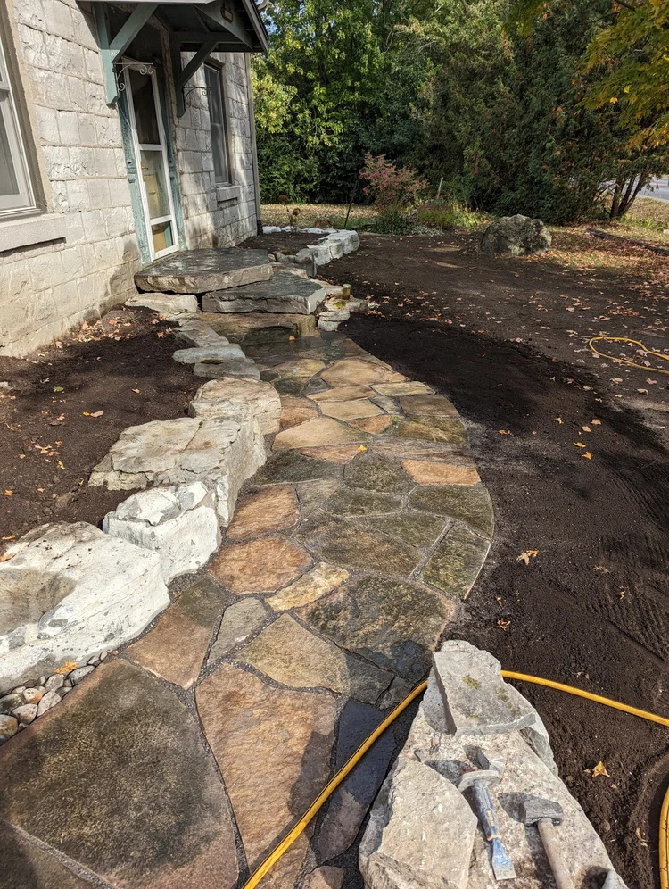 Flagstone walkway beside stone house exterior