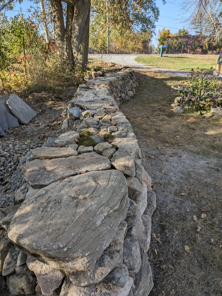 Rustic stone retaining wall beside rural road
