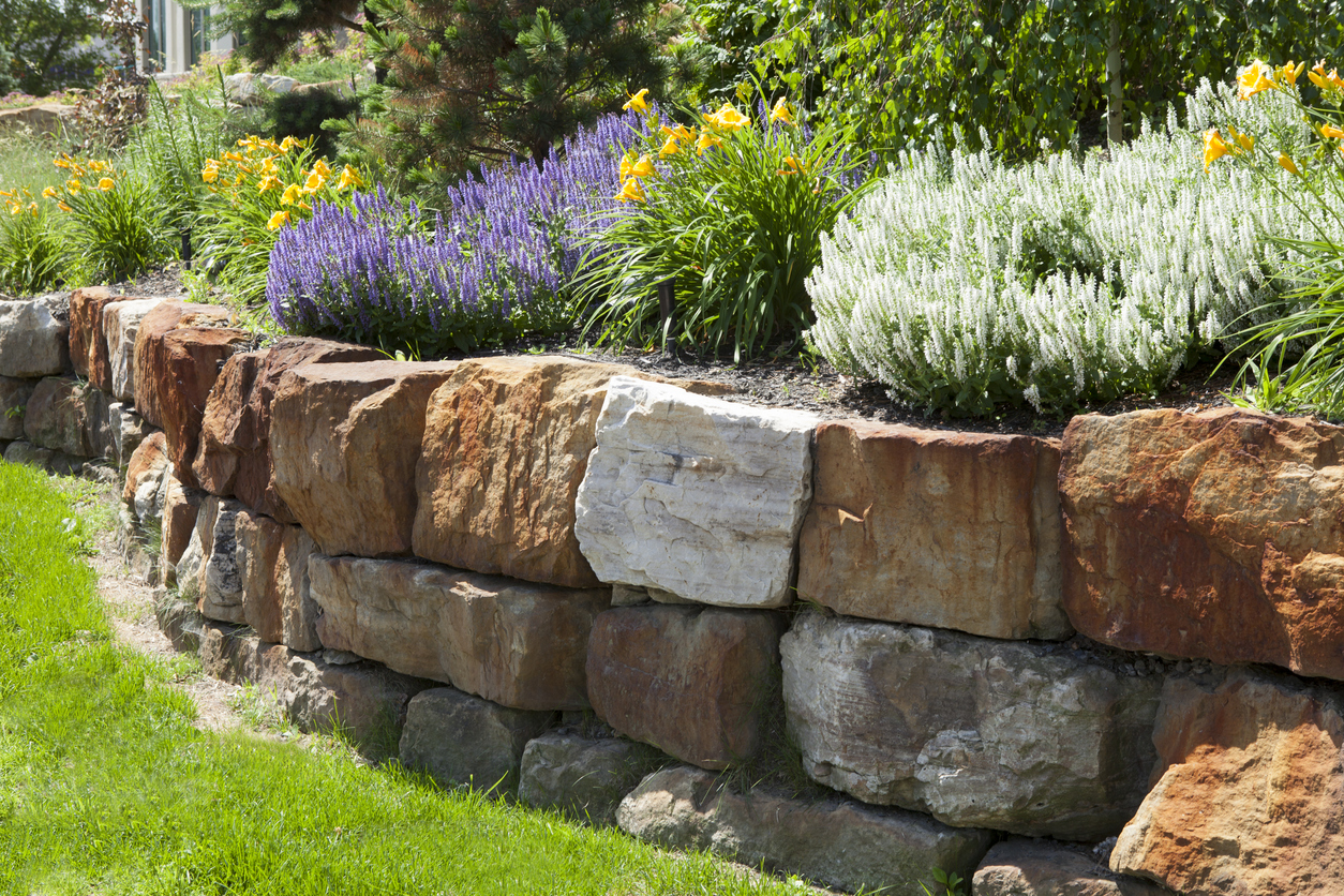 Stone retaining wall with colorful garden flowers