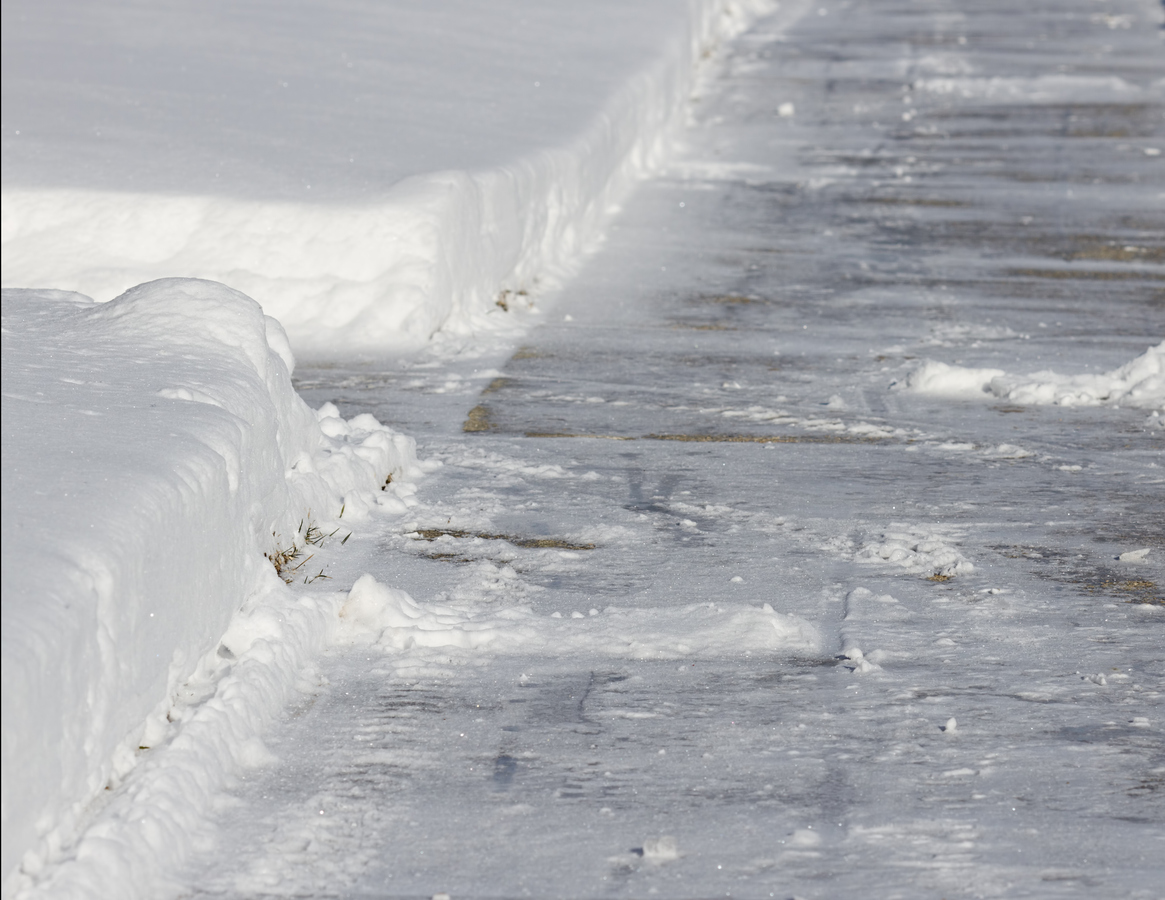 Icy sidewalk with snowbanks on either side