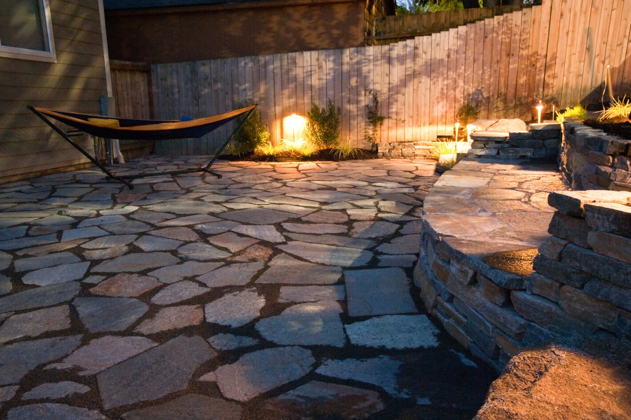 Stone patio with hammock and evening lighting