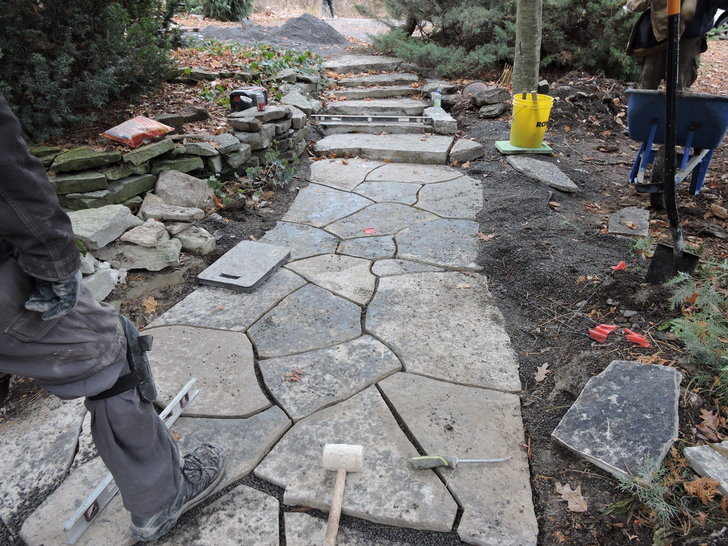 Workers installing irregular stone pathway and steps