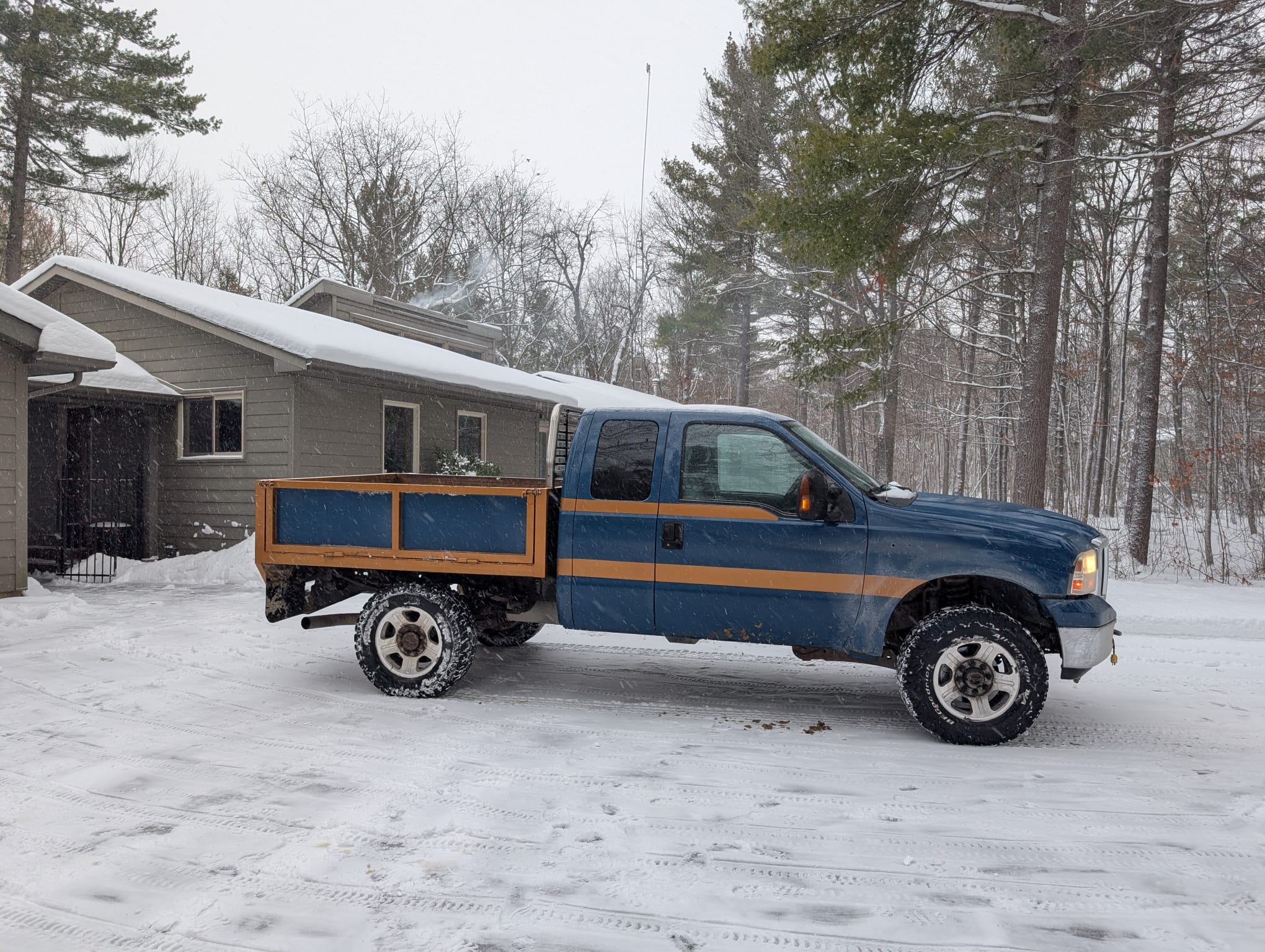 Blue pickup truck parked in snowy driveway