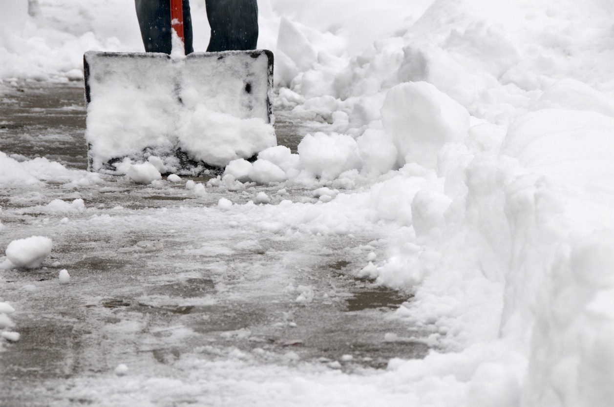 Person shoveling snow from sidewalk after snowfall